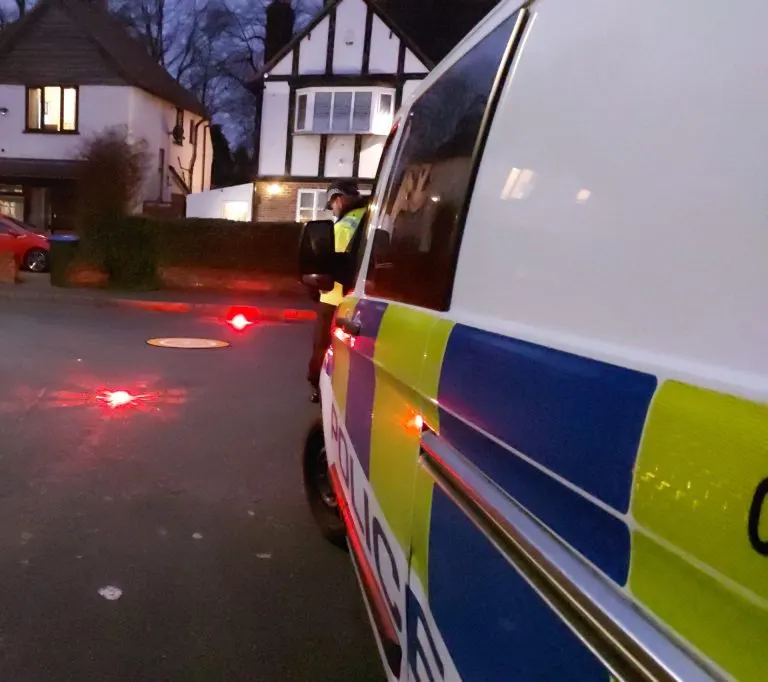 Police vehicle at an incident with red LED hazard beacons on the road